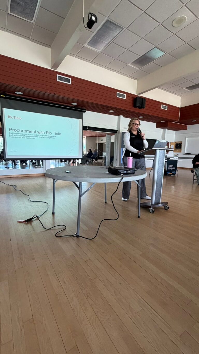 A presenter at a podium beside the projection screen.