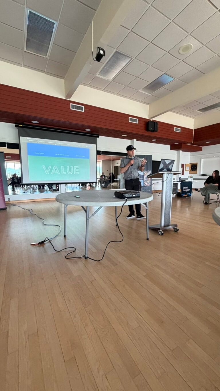 A presenter speaks beside the projection screen.