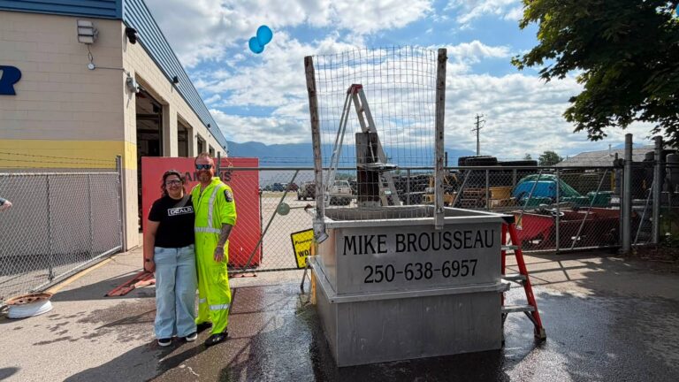 Two people stand beside the dunk tank.