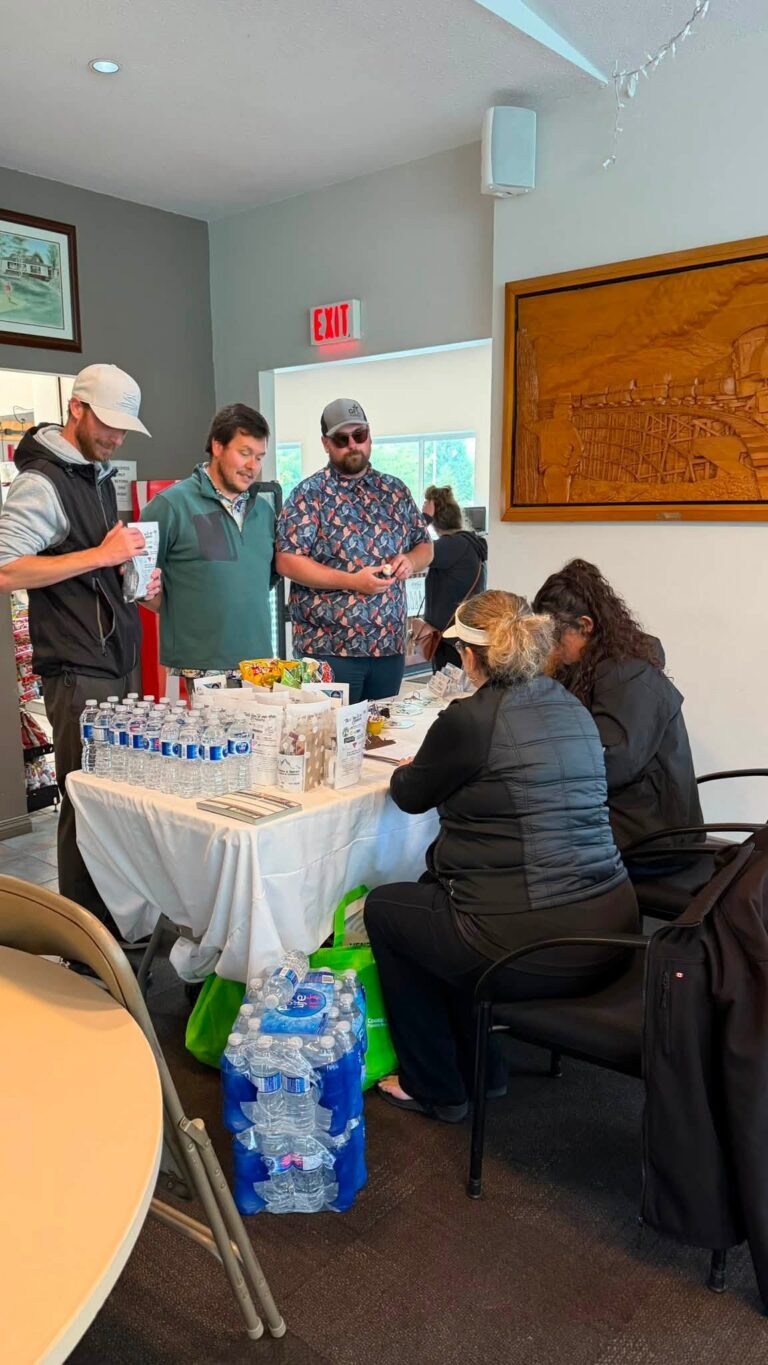 Golfers gathered around a snack and water table inside the clubhouse.