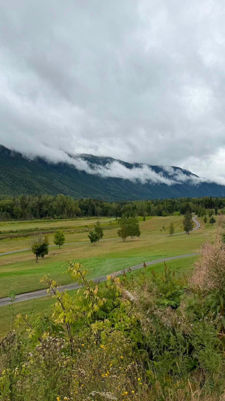 View over the golf course toward cloud-covered mountains.