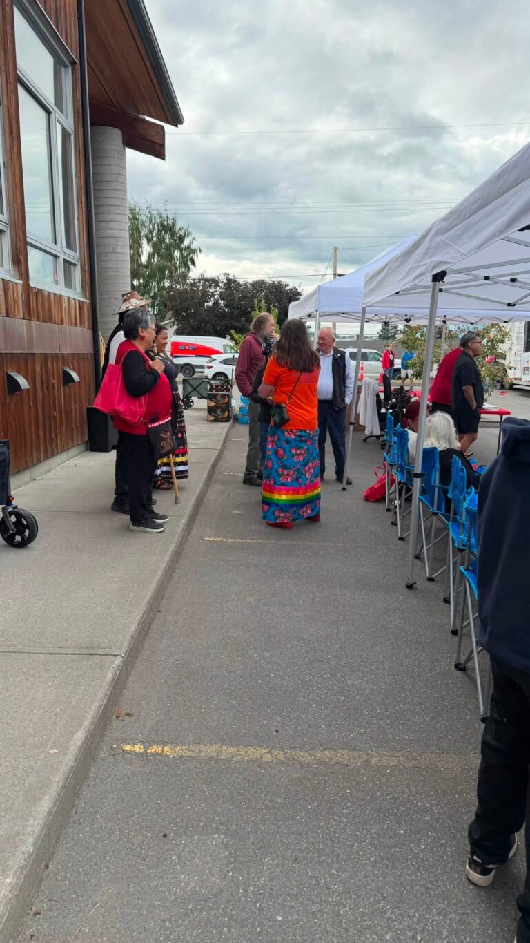 Guests gather on the sidewalk beside the event tents.
