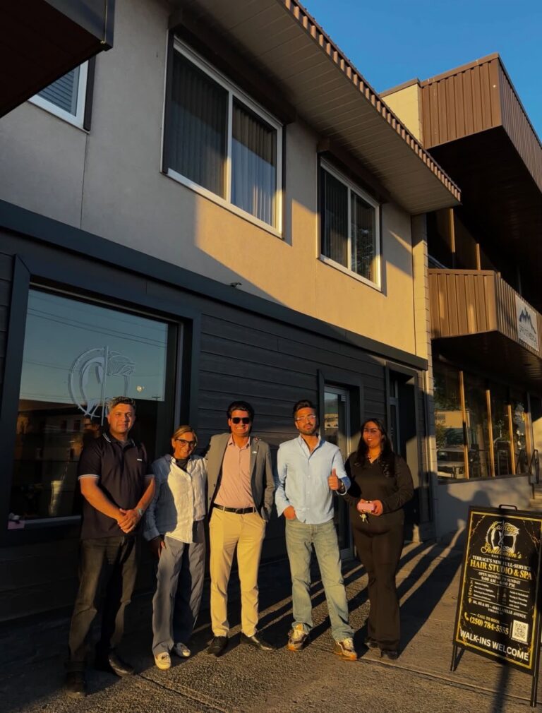 Five people stand outside Ladies & Gentlemens Hair Studio on Lazelle Ave.