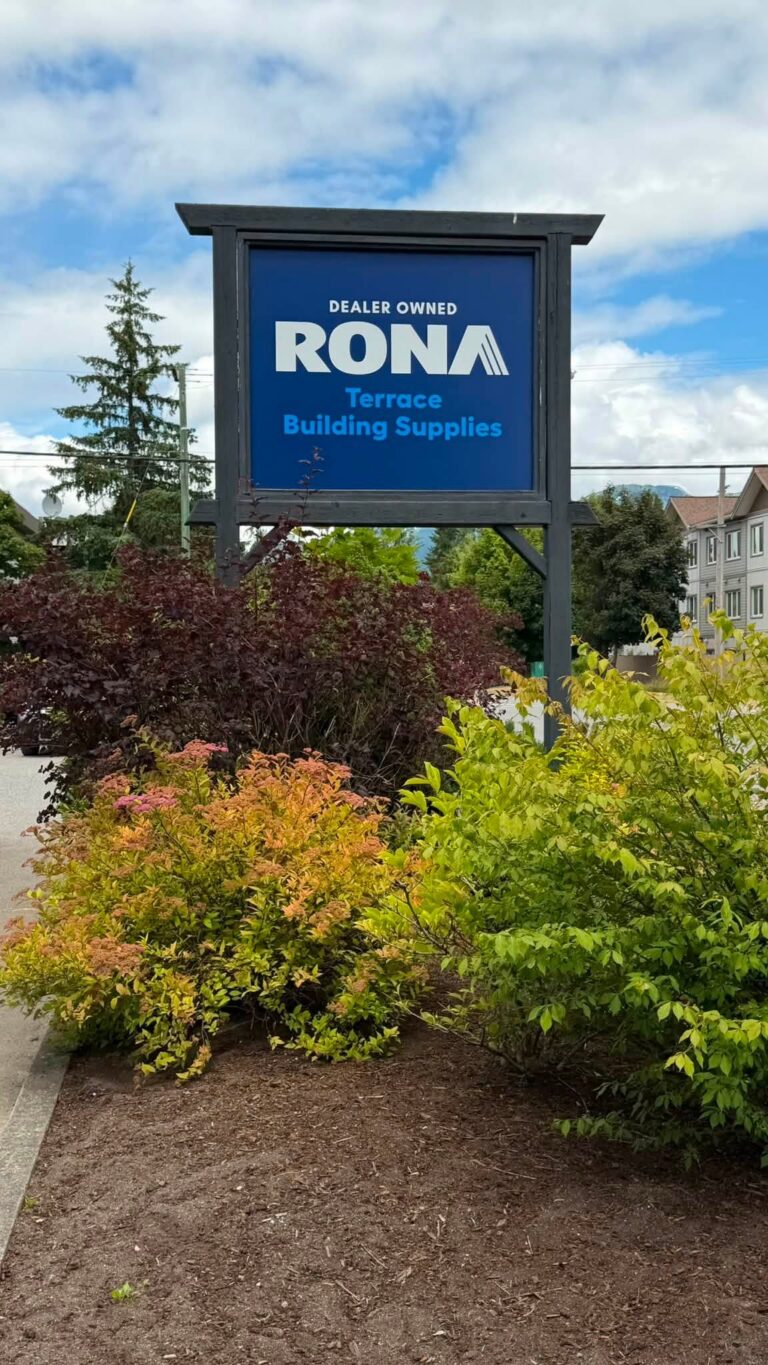 RONA Terrace Building Supplies sign beside a garden bed.