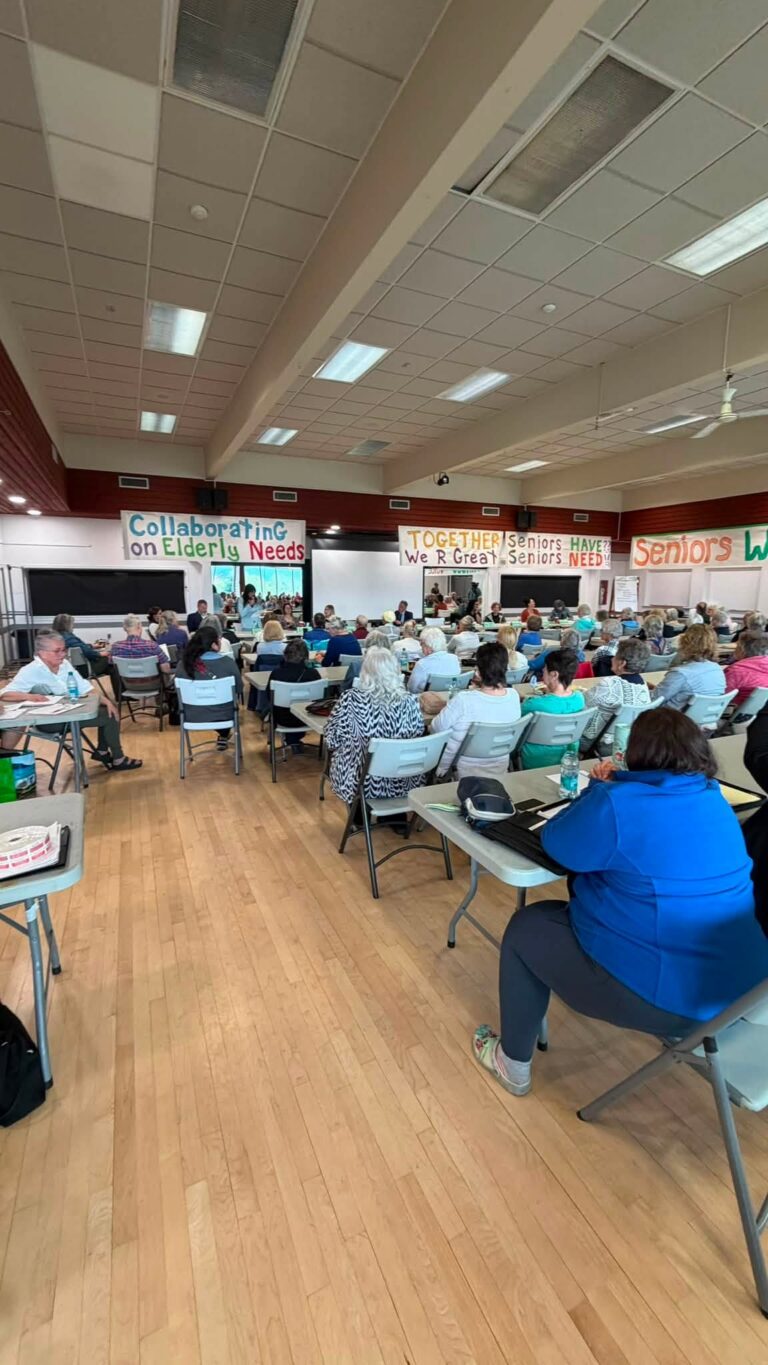 A full banquet room of attendees seated at long tables.