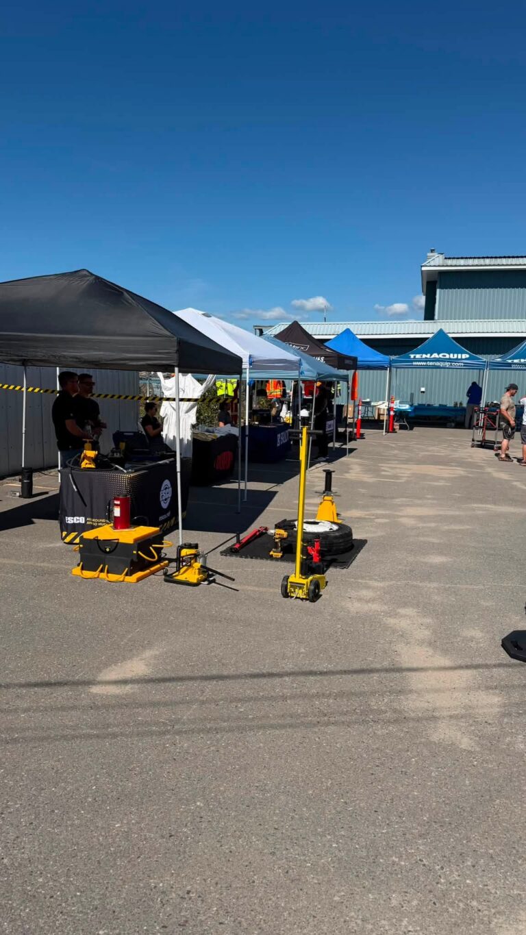 Vendor tents and tool displays outside the store on a sunny day.