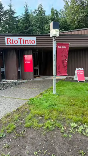 Entrance of the Rio Tinto building at BC Works with a red Rio Tinto sign and BC Works banners.